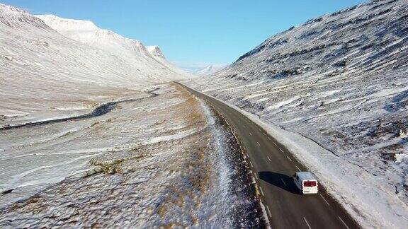 冰岛冬季的上坡道路景观柏油路两旁满是积雪