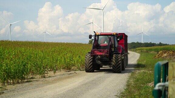 农用拖拉机在玉米地之间的道路上行驶