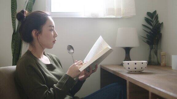 一个年轻女子在她的公寓里看书