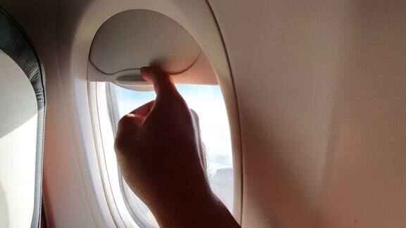 人们从飞机窗户往外看然后关上窗户