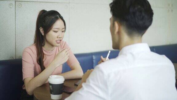 亚洲华人年轻商人在咖啡馆向他的客户解释投资计划