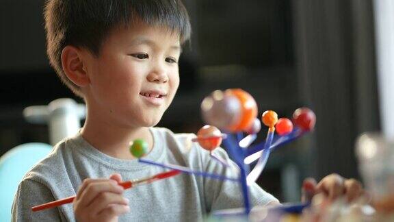 亚洲男孩画太阳系模型创造性和学习