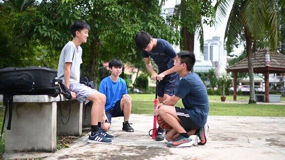 一群十几岁的亚洲华人男孩准备打篮球给篮球充气
