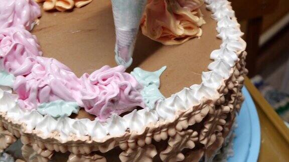 糖果女店员正在用糕点袋往海绵蛋糕上倒奶油这是特写镜头糕点师正在做自制的蛋糕烹饪烘焙烹饪家常菜