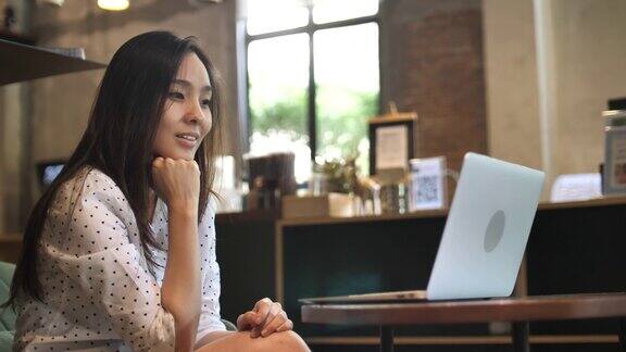 亚洲女人在咖啡馆使用笔记本电脑