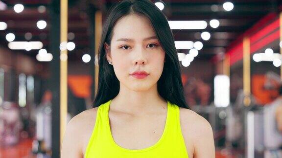 精力充沛的健身女运动员在健身房亚洲女运动员站在镜头前健身中心的美女美女和自信