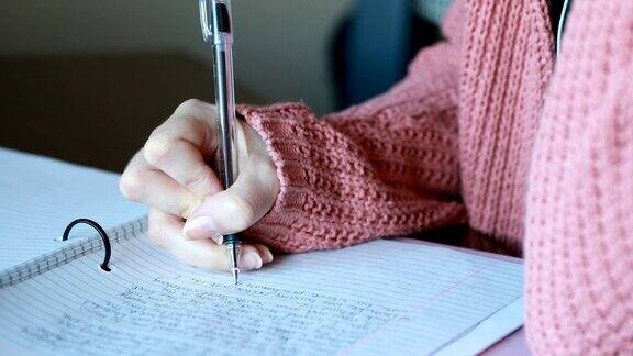 年轻女子一边写笔记一边学习