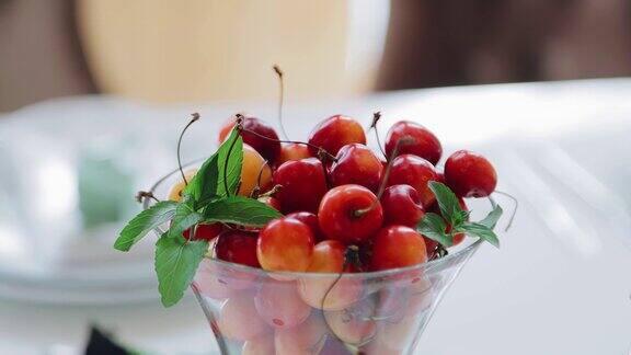 桌子上有一个透明的杯子里面装着凉爽的红色浆果拍摄浆果特写