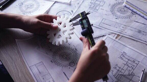 设计工程师检查3D打印的齿轮间隙和尺寸与游标卡尺