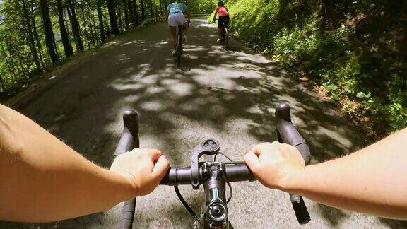 POV路自行车与两个女自行车下山的山路阳光