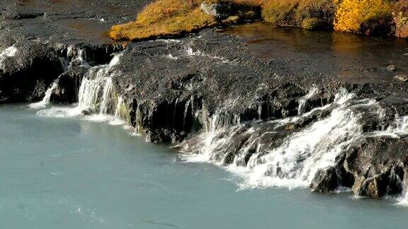 清澈的水从岩石流进湍急的浅蓝色山河