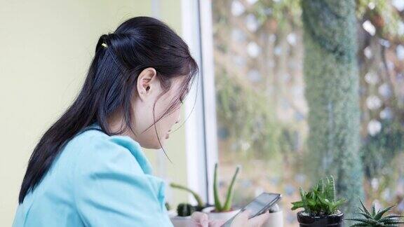 4K亚洲女性在咖啡馆用智能手机