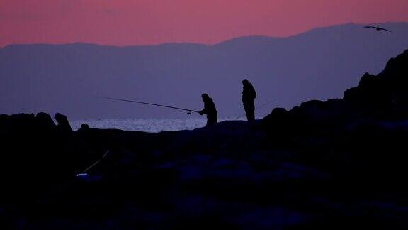 黄昏时分在岩石上钓鱼