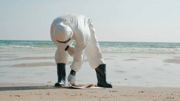 生态学家检查海滩上被污染的水