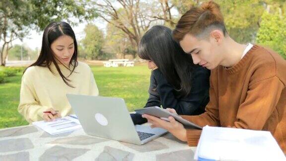 青少年亚洲学生小组分享在桌子上工作的想法