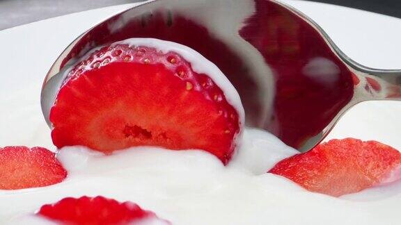 用勺子舀酸奶和草莓