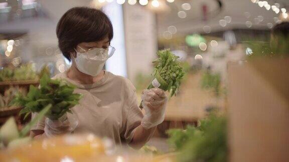 戴着防护口罩的女子在超市购物时使用环保袋