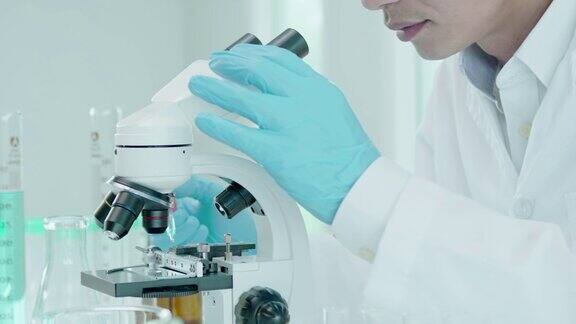 男科学家在先进的科学实验室分析生化样品医学专业人员用显微镜观察病毒的微生物发育实验室生物技术研究