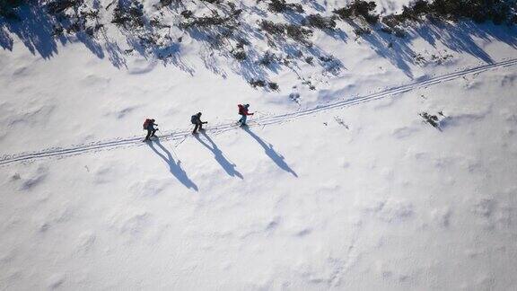 空中滑雪游客沿着山间小路滑雪