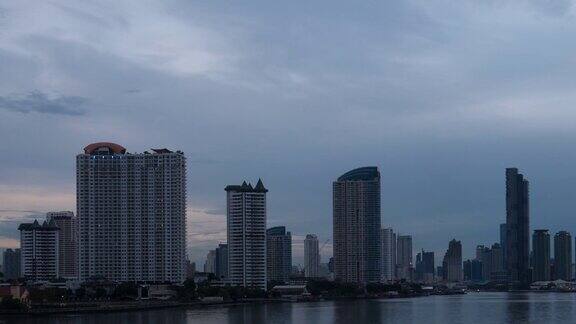 时间流逝白天到晚上的湄南河与现代建筑背景泰国曼谷;倾斜运动