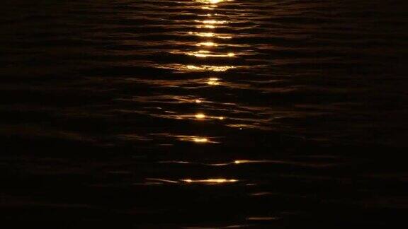 狭窄的阳光照射路径反射在漆黑的水中