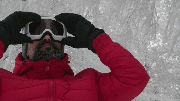 一个成熟的男人在滑雪场雪地上戴上滑雪眼镜的特写肖像赏冬山准备在白雪皑皑的山上滑雪下坡滑雪