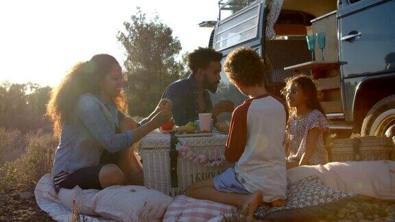 日落时分一家人在露营车外野餐