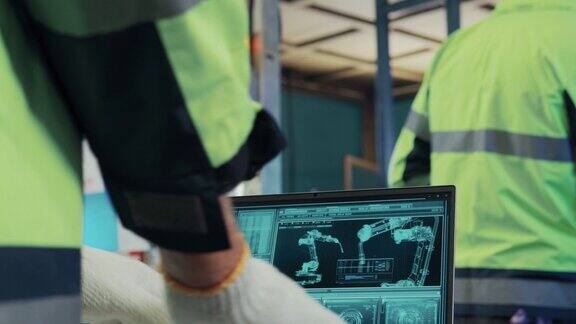 4K男、女工程师检查机器人手臂的运动用于现代工厂自动化生产线的质量控制