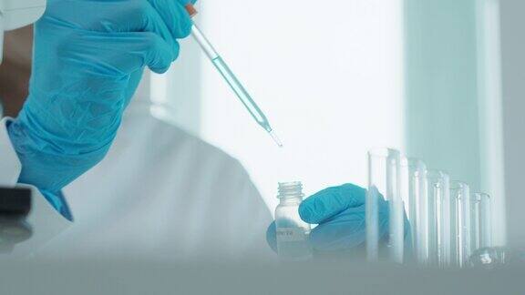 科学家在先进的科学实验室里分析生化样品医学专业使用滴管混合微生物发育的病毒实验室生物技术研究化妆品