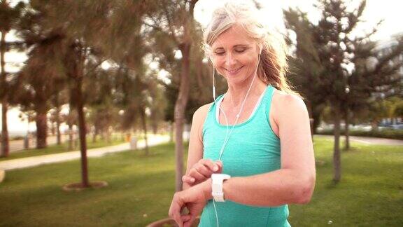 运动型老年女性用智能手表监控自己的跑步表现