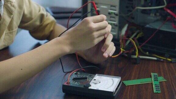 图为亚洲学生在教室里使用测量仪器修理电子电脑硬件