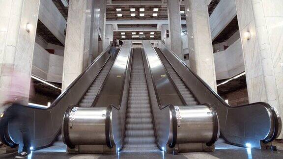 人们在繁忙的地铁站登上火车和乘坐自动扶梯的时间流逝