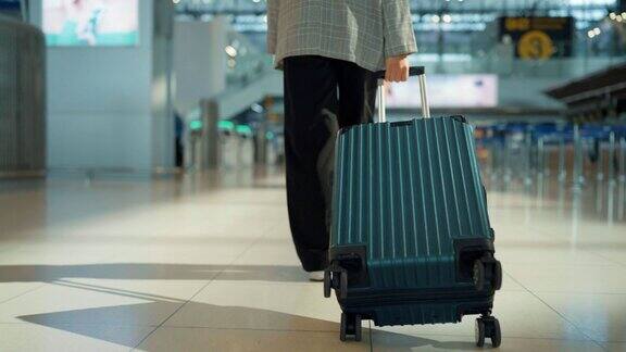 亚洲女商人拿着护照和行李走在国际机场