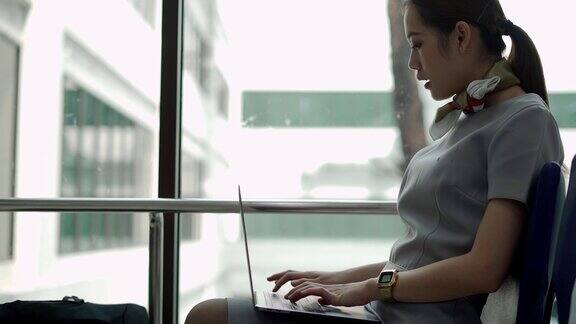 女商人在机场大厅使用智能手机和笔记本电脑