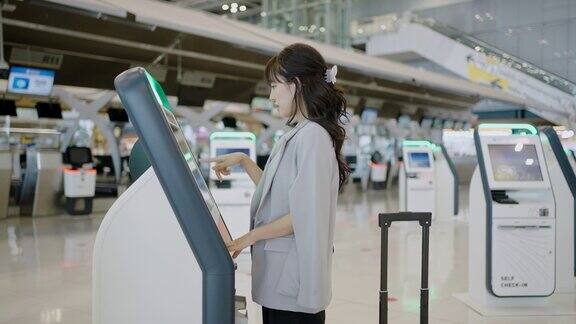 一名亚洲女子在机场候机楼自助值机