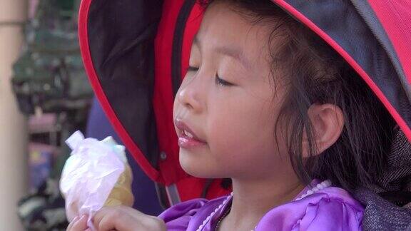 4k:亚洲美丽的孩子小女孩吃冰淇淋