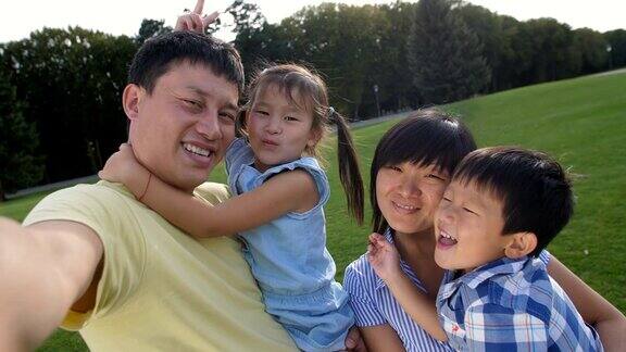 幸福的亚洲家庭在手机上自拍