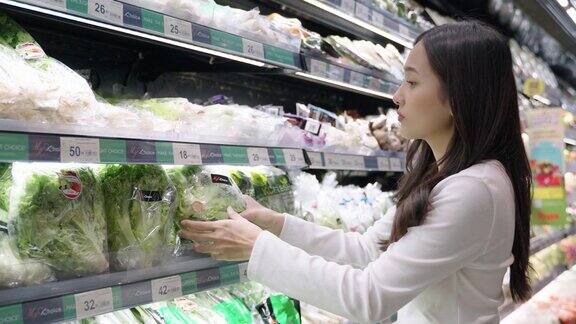 年轻女子在商场挑选蔬菜