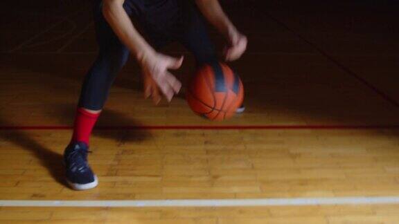 腿的特写卷发的白人篮球运动员运球镜头专业的黑暗光线