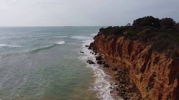 海浪拍打着荒芜的海滩上的悬崖