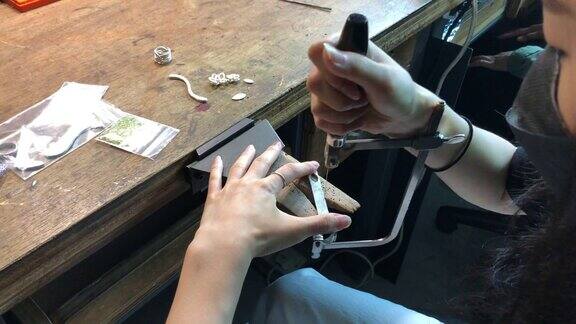 高角度的亚洲韩国女学生使用手锯在大学工作台