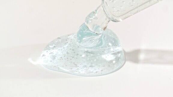 液体液体蓝色凝胶或血清滴在白色表面上面有气泡的化妆液滴管