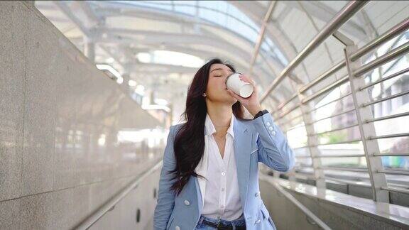 4K亚洲女商人喝热咖啡步行办公中心区在早上