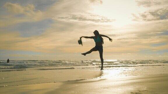 年轻女性在沙滩上尽情起舞是度假、旅游、休闲