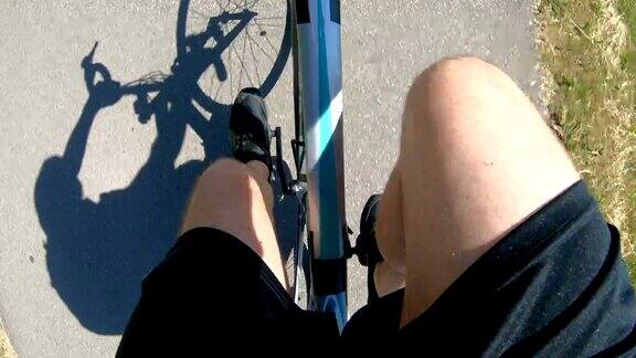 骑着自行车在柏油路上投下阴影