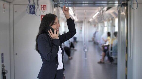 亚洲女商人在地铁上打电话
