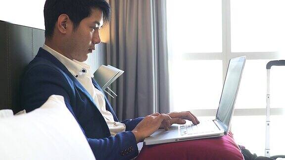 4K:一个商人在酒店房间里用键盘打字