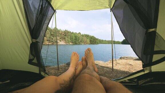 一对夫妇在瑞典湖边的帐篷里露营