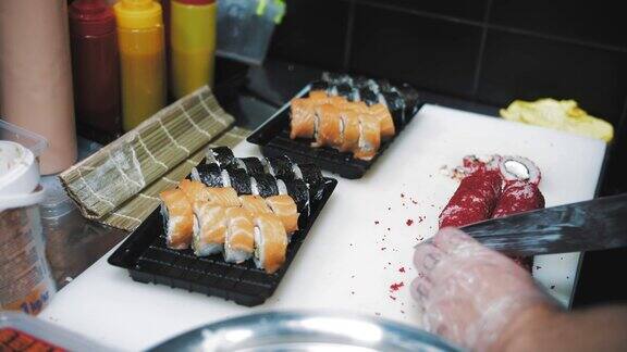 寿司日本的食物烹饪烹饪特写镜头寿司师傅正在白板上用刀把寿司卷切成小块亚洲食品食品交付外卖食品
