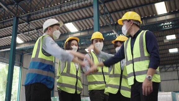 一群亚洲工人在工厂里手拉手